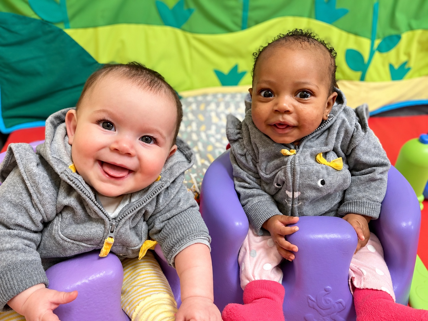 Two infants share a quiet moment together in the classroom.